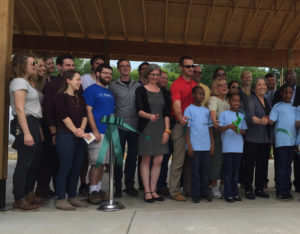 A group of adults and children at the ribbon cutting ceremony.